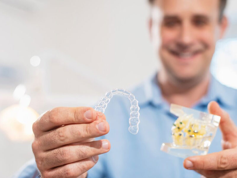 a man holding dental aligners